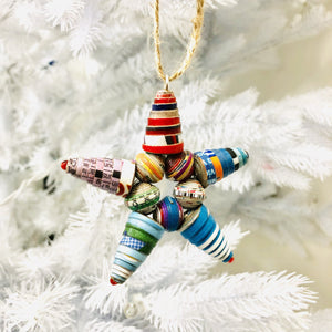 Colorful cereal box bead star ornament on white Christmas tree background