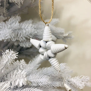 White paper bead ornament on white Christmas tree. 